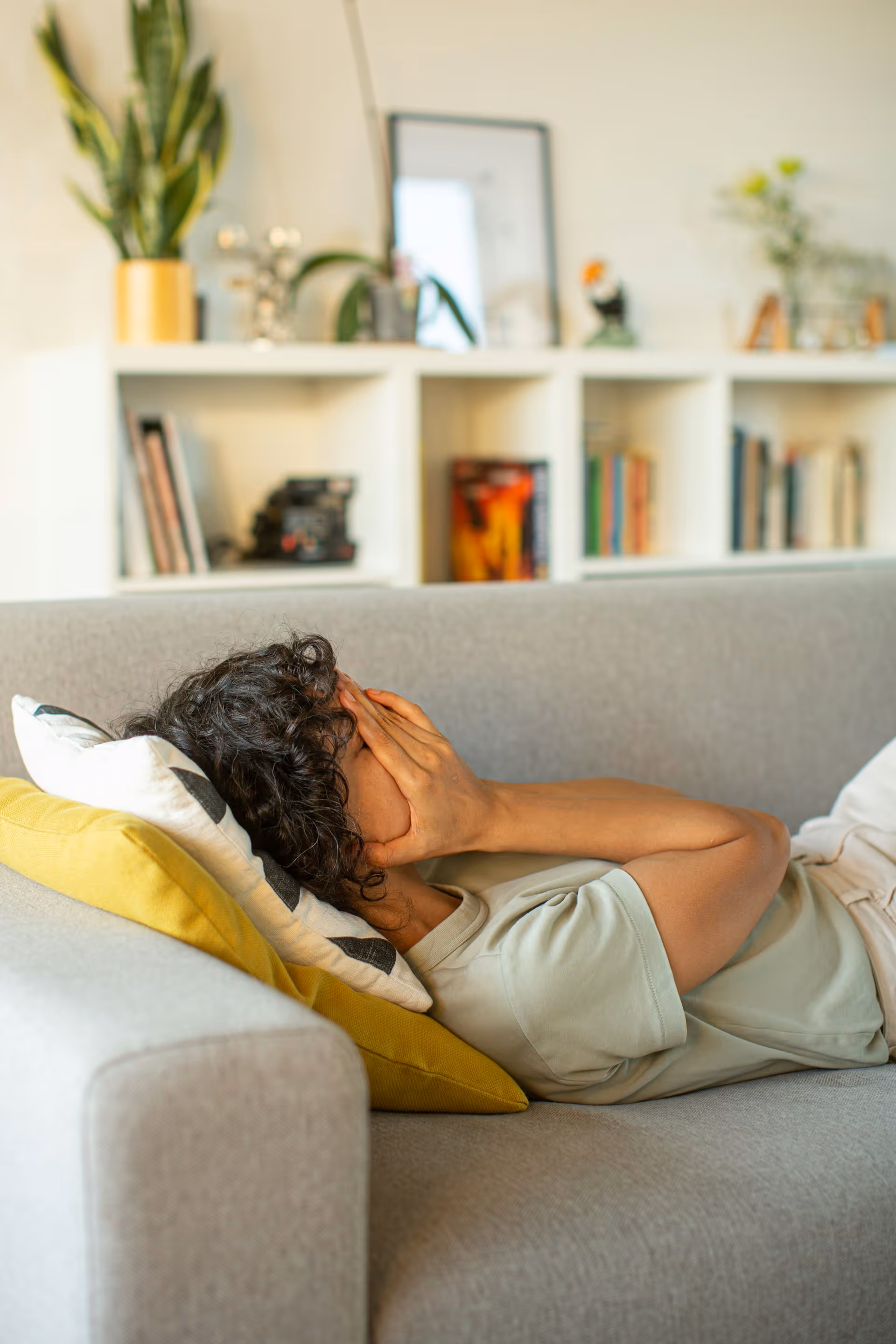 Professional resting on couch appearing fatigued after work.