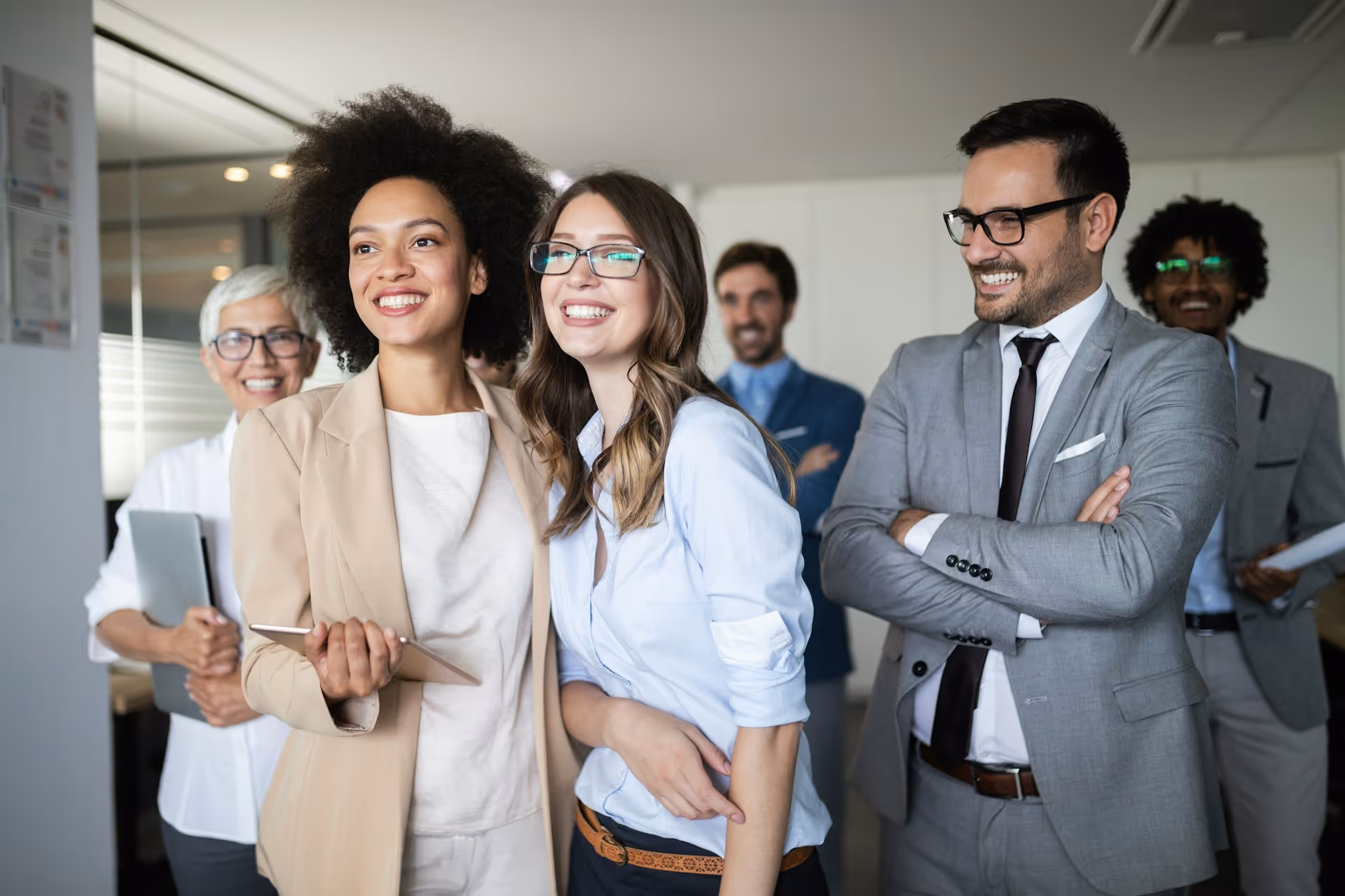 Professional team standing confidently in an office environment.