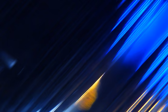 Blue and black blurred light streaks with a small golden yellow highlight.
