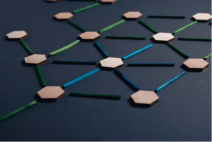 Wooden hexagons connected by colorful sticks on dark surface, forming a network pattern.
