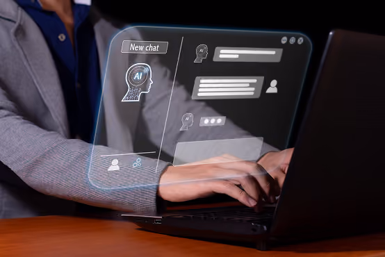 Person typing on a laptop with a holographic AI chat interface floating above the keyboard.