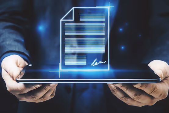 Person holding tablet with a glowing digital document and signature hologram above the screen.