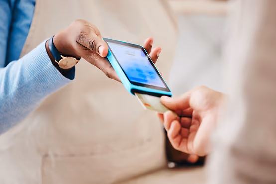 Close-up of a contactless payment being made with a card reader and mobile phone.