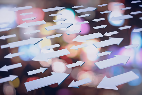 Multiple white arrows pointing right on a blurred colorful background.