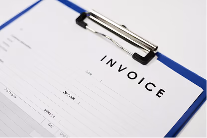 Close-up of an invoice document on a blue clipboard with visible header and form fields.