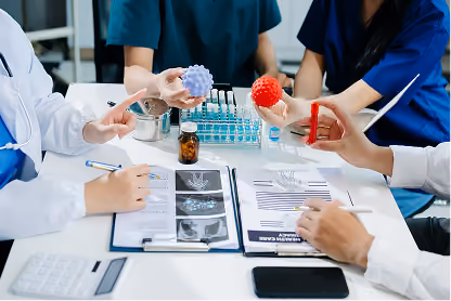 Medical professionals holding virus models and discussing brain scan images at a table.