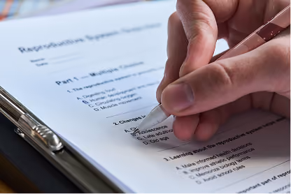 Hand holding pen filling out multiple-choice reproductive system test on clipboard.