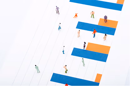 Miniature figurines placed on an abstract, striped chart with orange and blue bars.