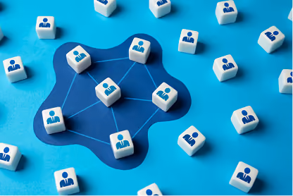 White cubes with blue person icons connected by lines on blue surface representing network connections.