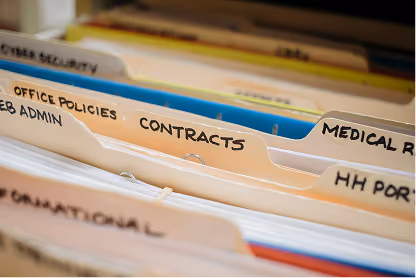 Close-up of labeled file folders including Office Policies, Contracts, and Medical Records.