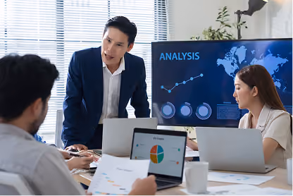 Businessman presenting analysis on screen to colleagues in a modern office meeting.
