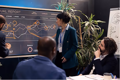 Businesswoman presenting financial report on large screen to colleagues in office meeting.
