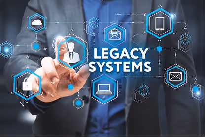 Businessman pointing at digital icons around the text Legacy Systems on a dark blue background.