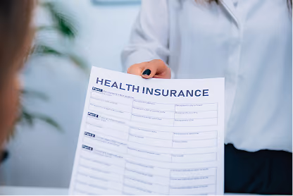 Person in white shirt holding a printed health insurance form toward another person.