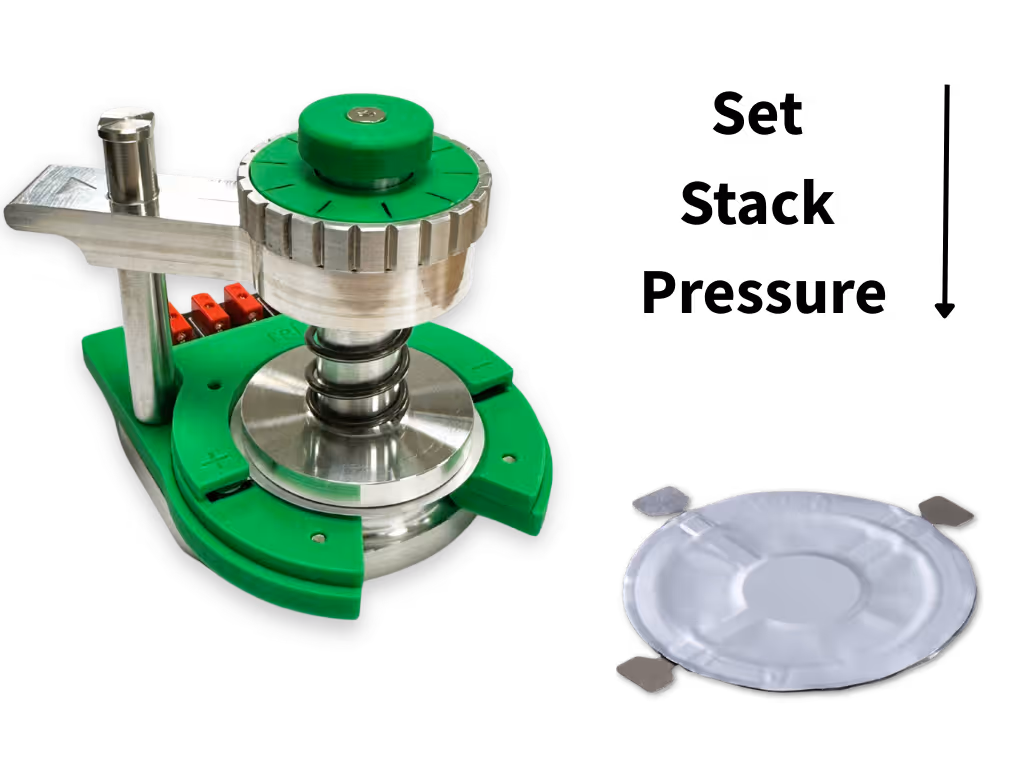 Metal and green plastic test holder device with a round white membrane filter beside it on a white background.