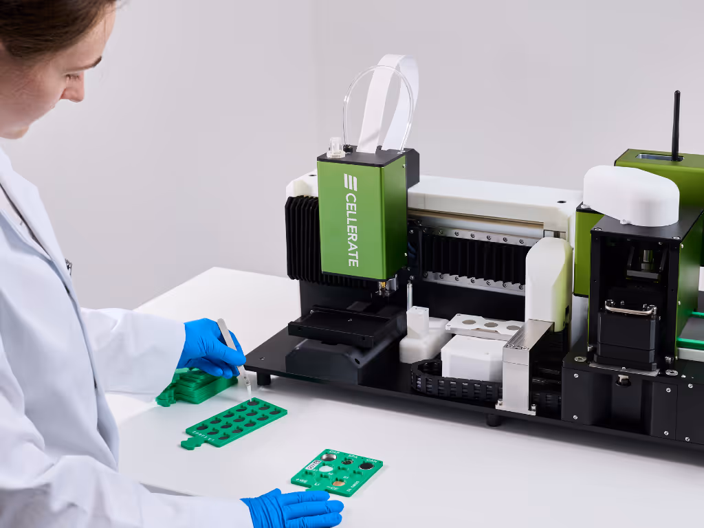 Close-up of a laboratory machine with green and white trays holding circular sample slots.