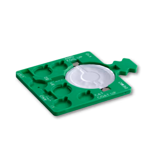 Green plastic tray with several circular slots and a central large circular part, used for organizing or holding small components.