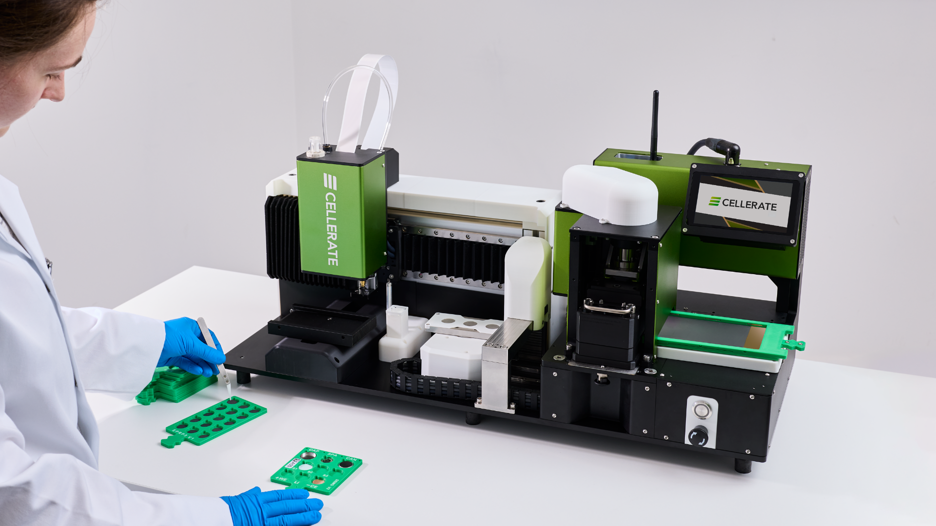 White and green laboratory glovebox isolator with transparent front and touchscreen control panel on the right side.