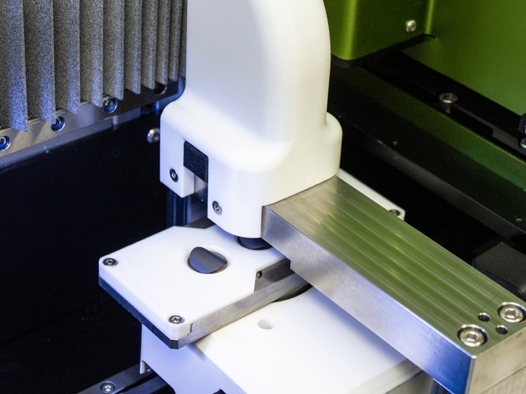 Close-up of a electrode preparation machine measuring the thickness of a black disc.