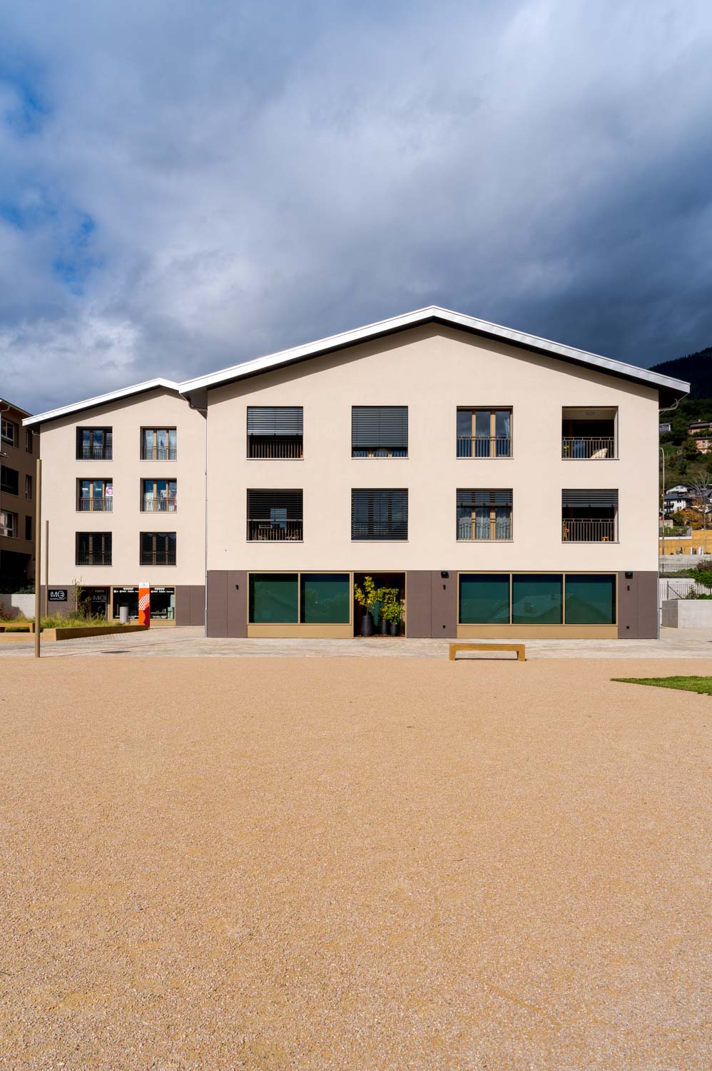 Photo Architecturale extérieur d'un grand complexe d'habitation et de commerces de proximités à Savièse