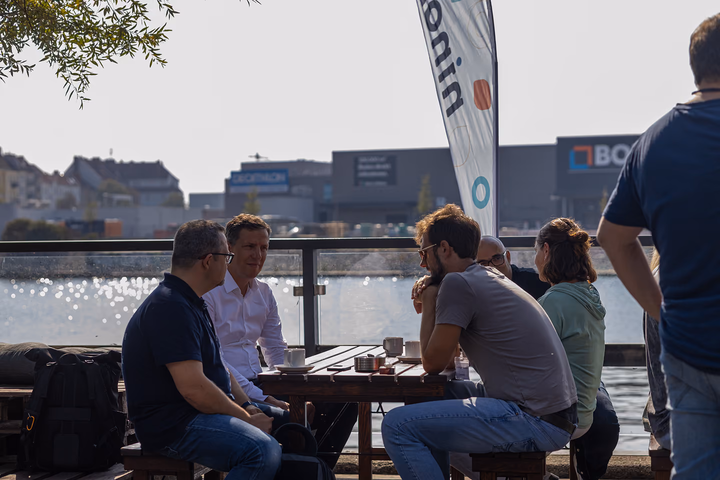 Ninox CFO Daniel, talking to two other guys while drinking a beverage