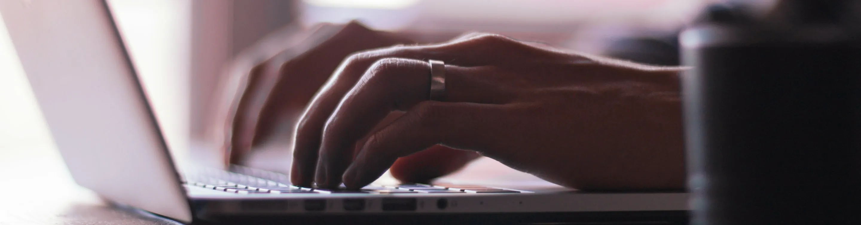 Close-up of hands typing on a laptop keyboard