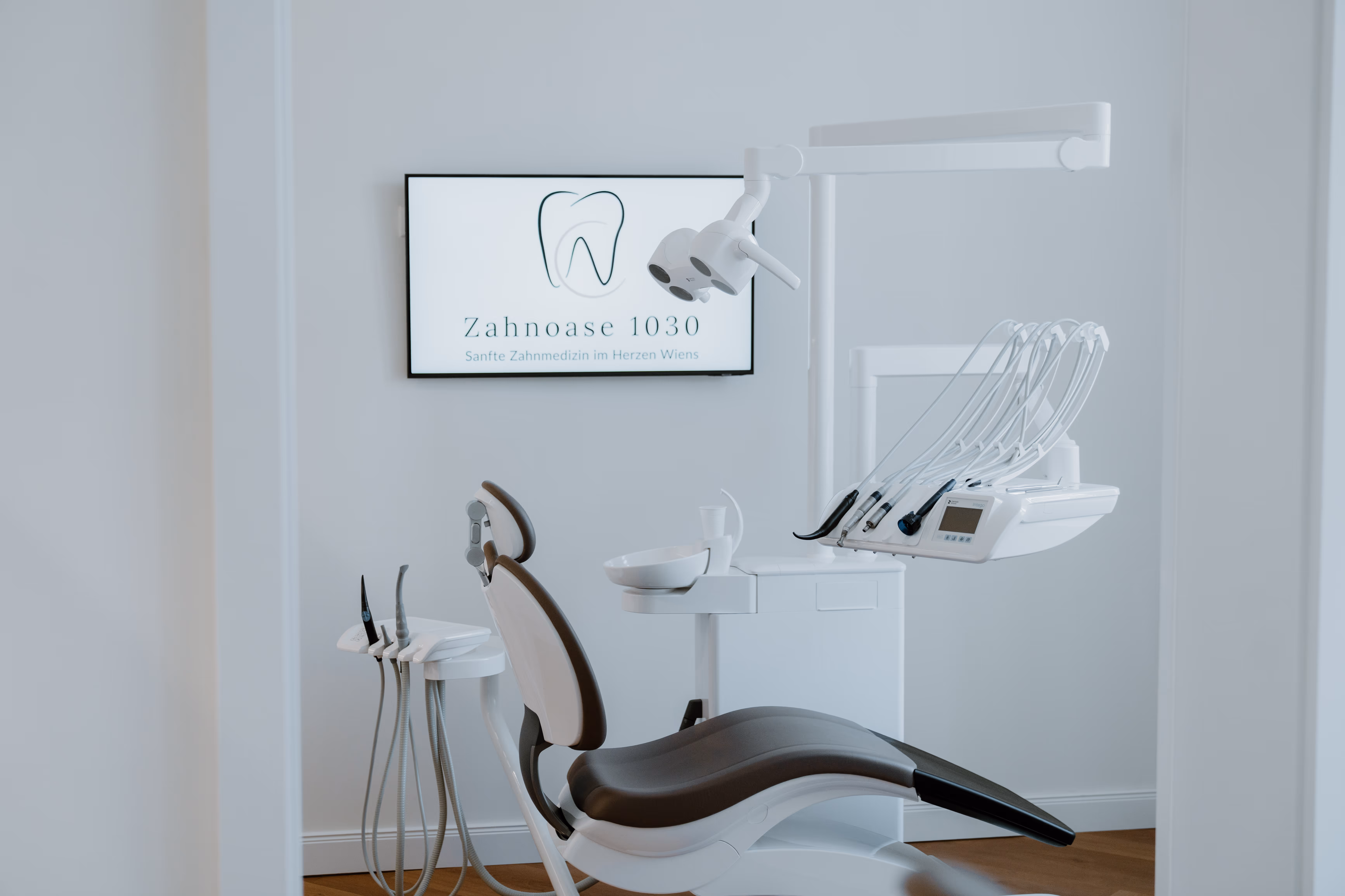 Moderne Zahnarztbehandlungseinheit mit Behandlungsstuhl und zahnärztlichen Instrumenten in einer hellen Praxis.
