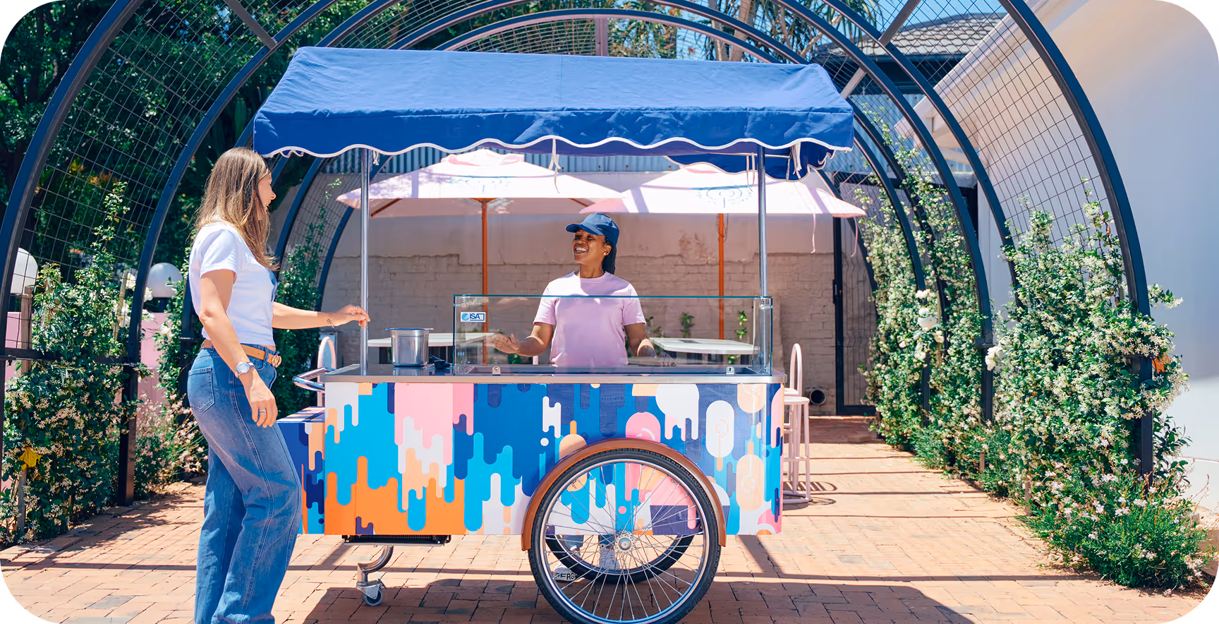 Black signboard mounted on a pole displaying the Tecbot logo and website tecbot.co.za along a street with parked cars and buildings in the background.