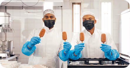 Man in black hoodie working on a laptop displaying a graphic design software at a desk in an office at Tecbot.