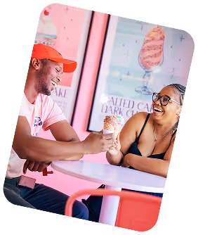 Person wearing gloves dispensing soft serve ice cream into a cone from a machine.