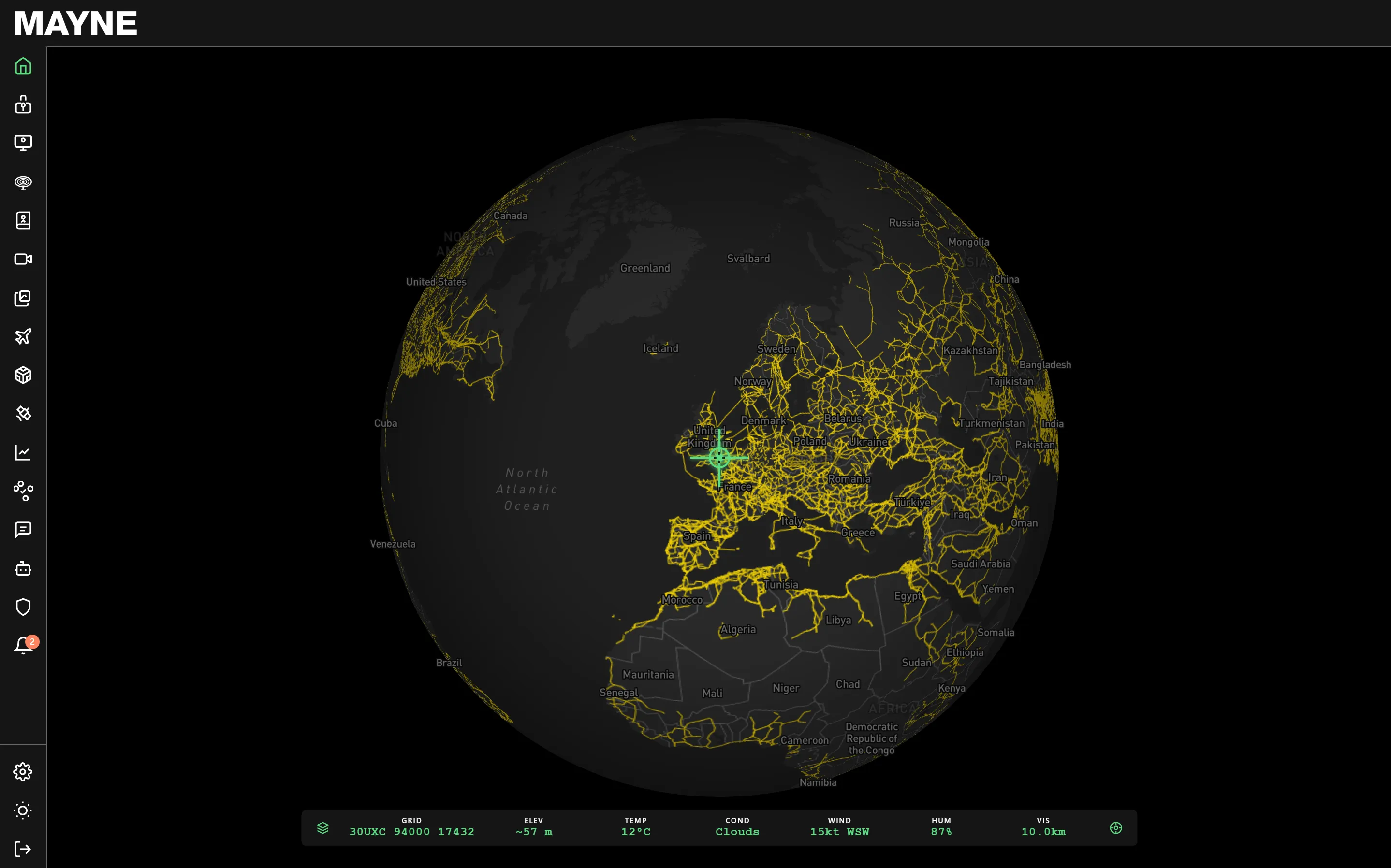 Digital globe centered on Europe with yellow flight paths and a green target icon over the United Kingdom shown on a black MAYNE flight tracking interface.