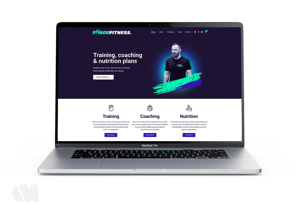 MacBook Pro displaying Forge Fitness website homepage with training, coaching, and nutrition plans.