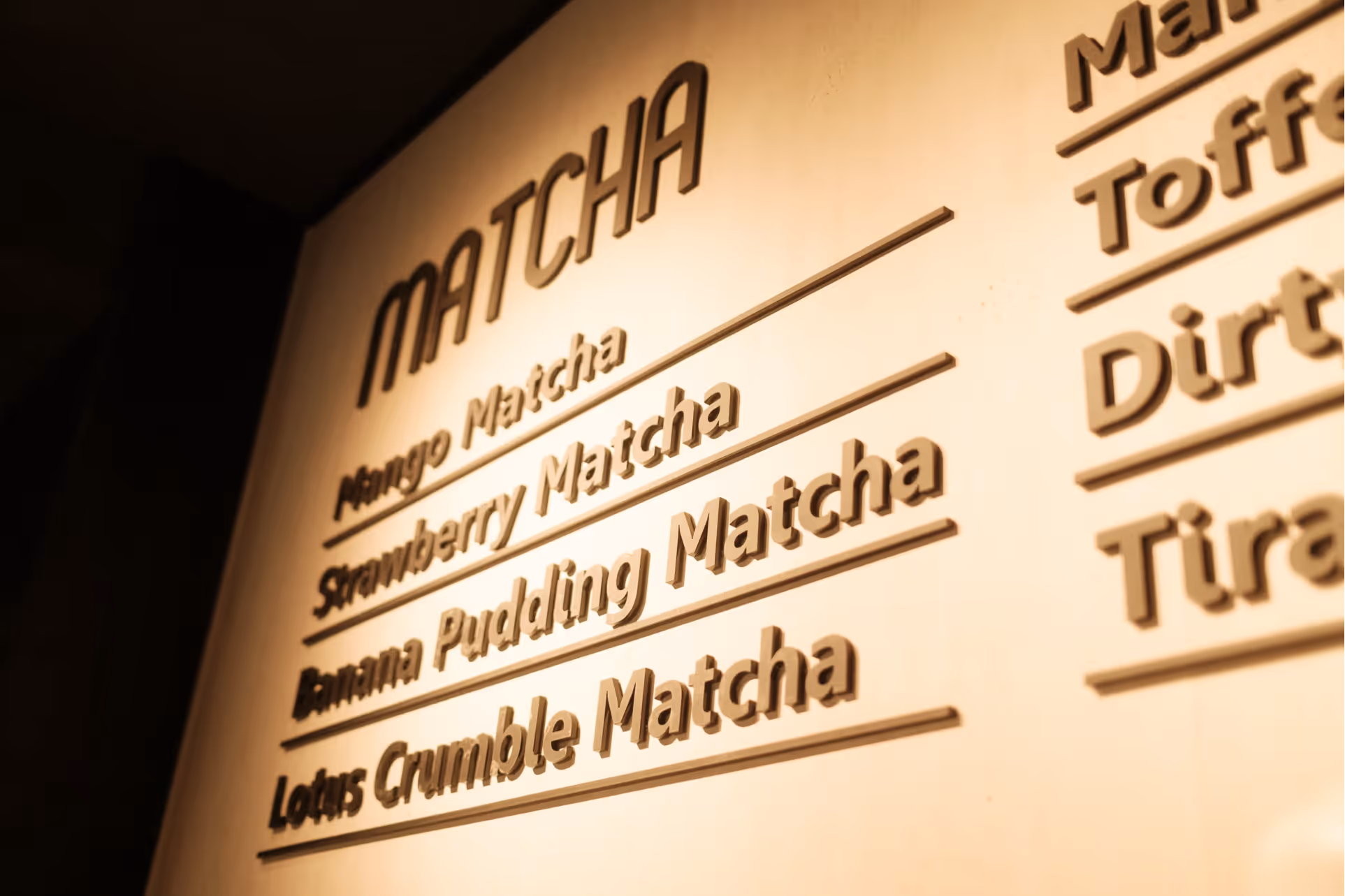 Menü mit verschiedenen Matcha-Geschmacksrichtungen wie Mango, Erdbeere, Bananenpudding und Lotus-Crumble.