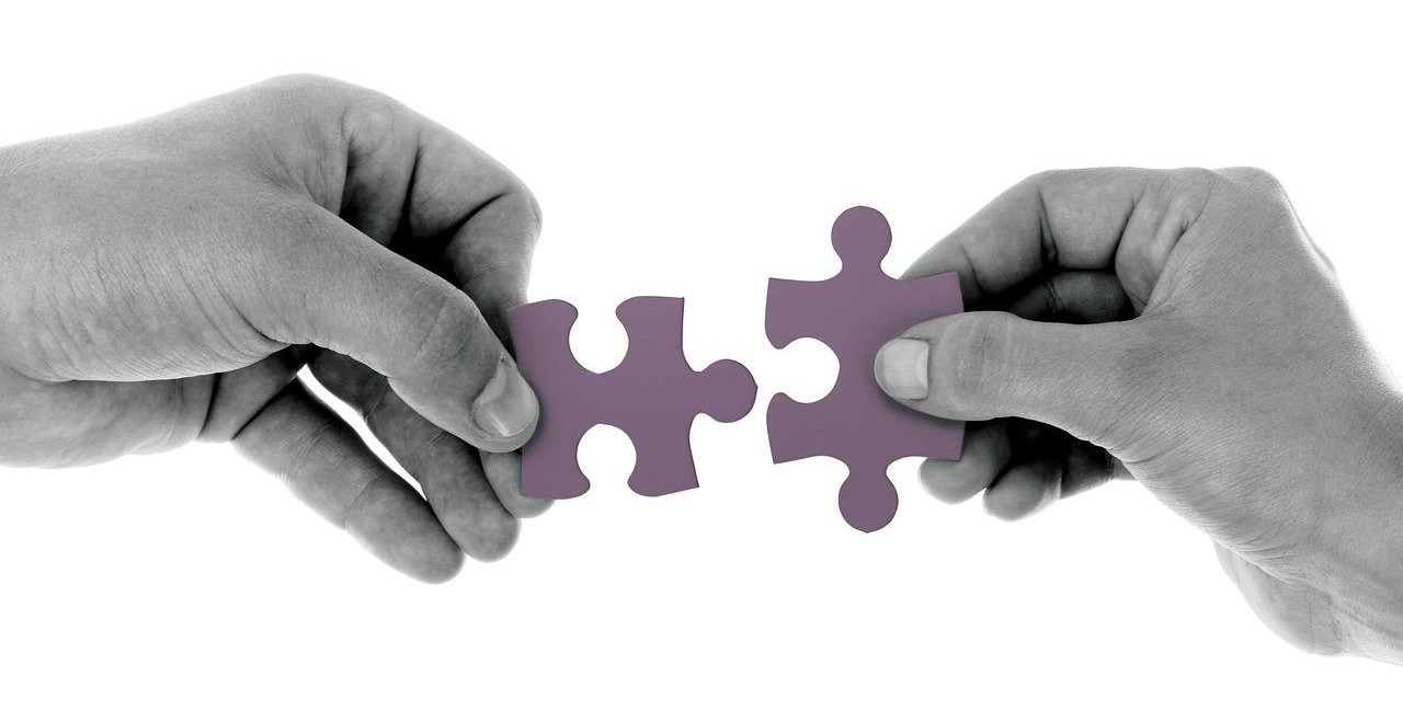 Hands putting puzzle pieces together