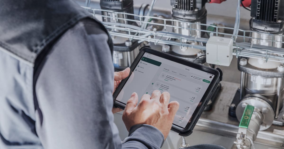 A maintenance technician using a work order app on a tablet