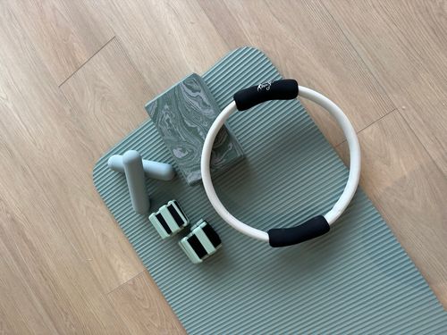 Woman in blue workout outfit doing a side plank on a yoga mat indoors.