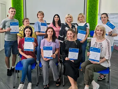 Учасники навчання з наставництва тримають сертифікати після зустрічі.