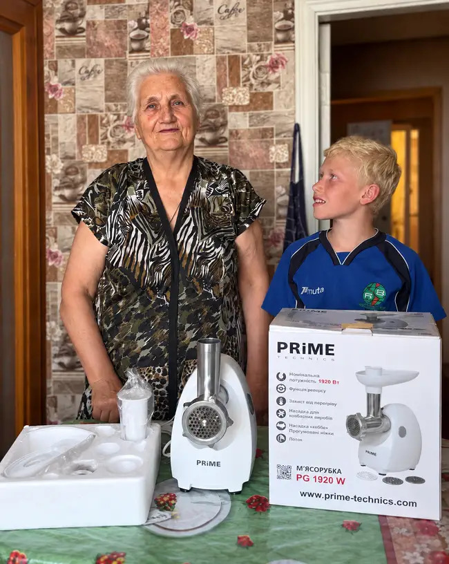 Tsesia Andriivna and her grandson Oleksandr with their new meat grinder