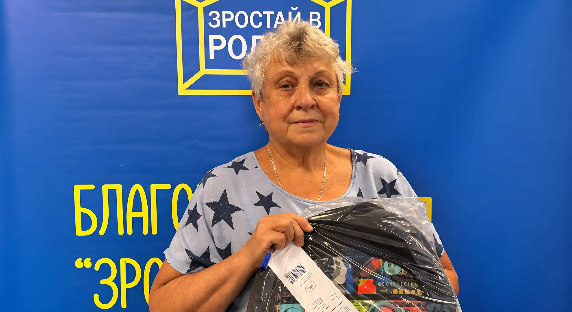 Опікунка з пакунком одягу на заході фонду «Зростай в родині»