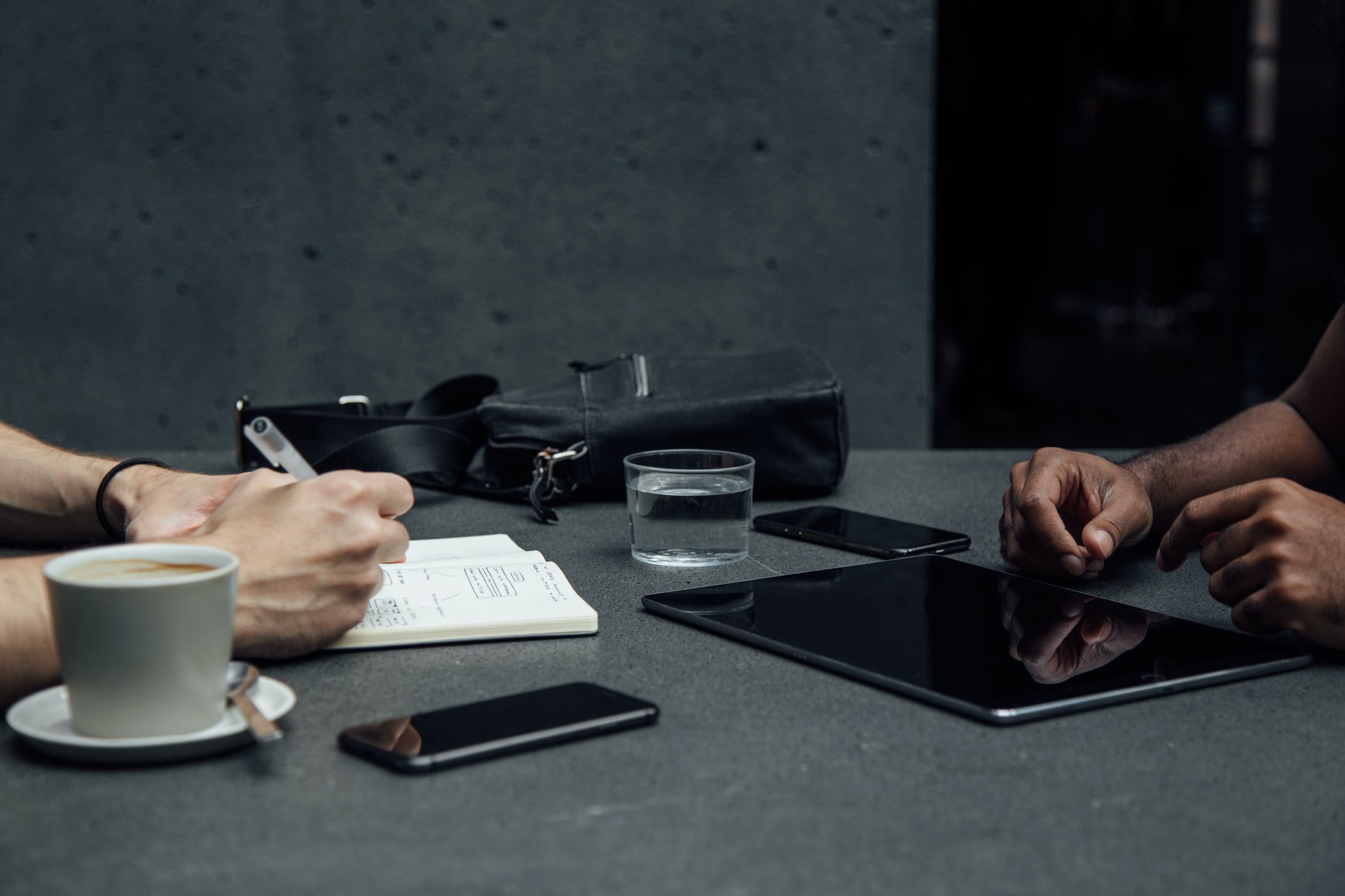 Schreibtisch mit Laptop, Kaffee und arbeitenden Händen