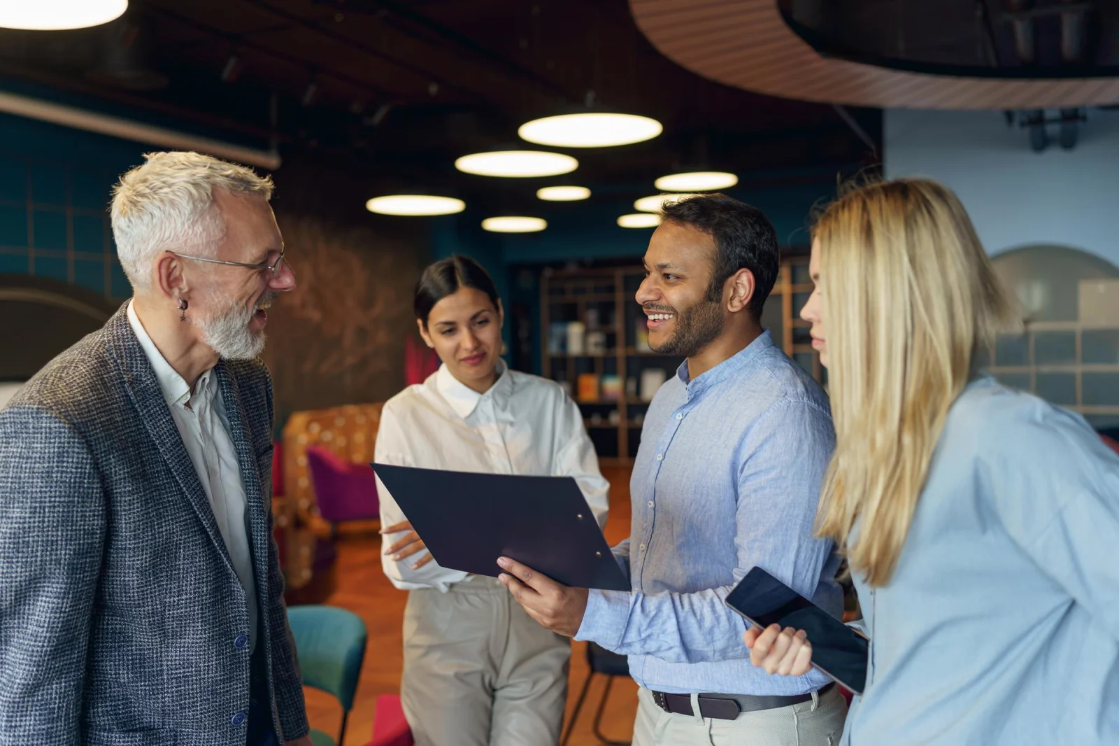 Manager orchestrant l'intégration technologique PMS et Channel Manager avec ses collaborateurs en réunion stratégique