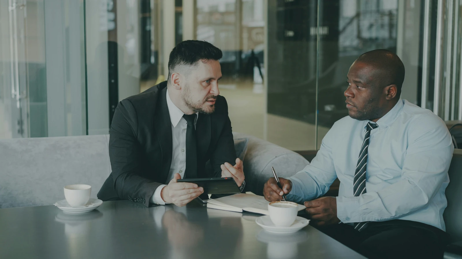 Consultante en entreprise révisant des documents contractuels avec un client dans son bureau