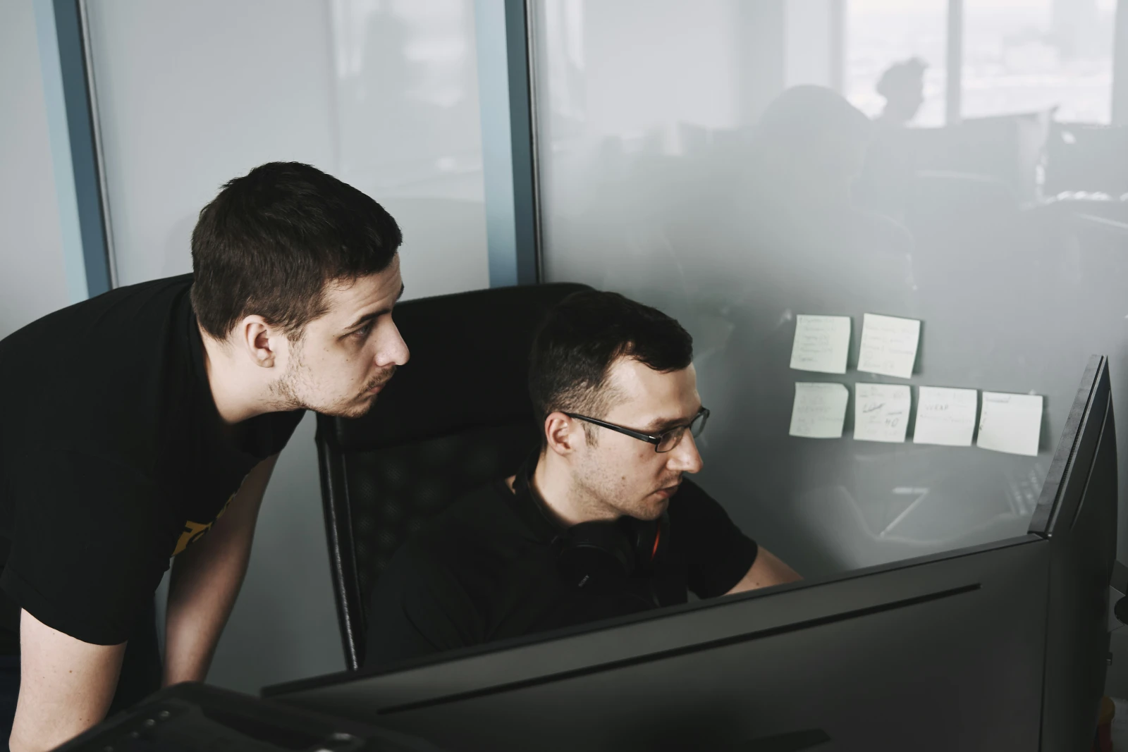 Manager supervisant et coachant un agent service client sur écran d'ordinateur au bureau