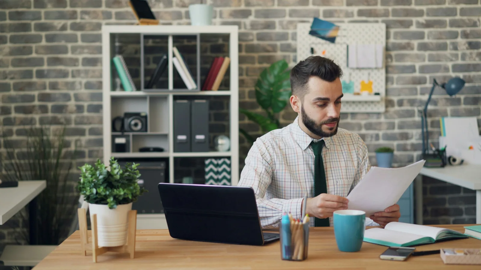 Spécialiste RH vérifiant des documents de paie et d'administration sur son bureau