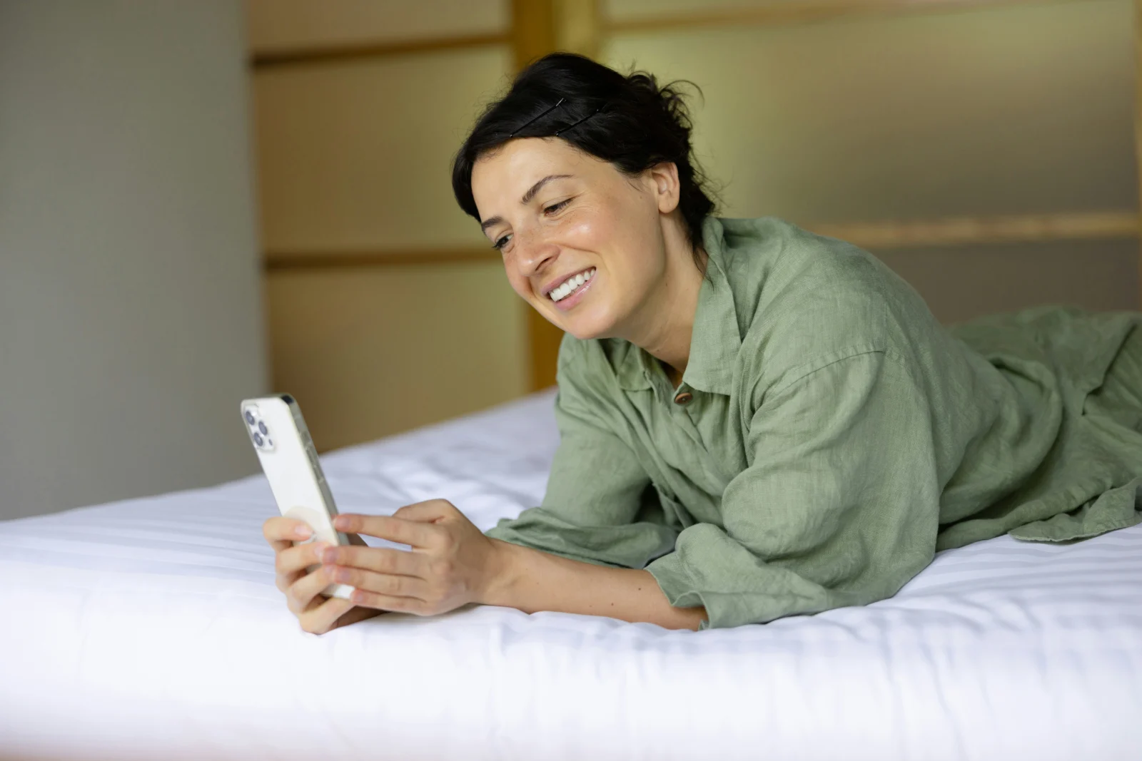 Client d'hôtel consultant un email de bienvenue personnalisé sur son smartphone dans sa chambre