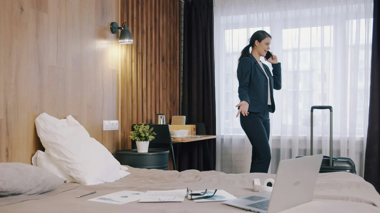 Manager en déplacement professionnel contactant l'assistance depuis sa chambre d'hôtel