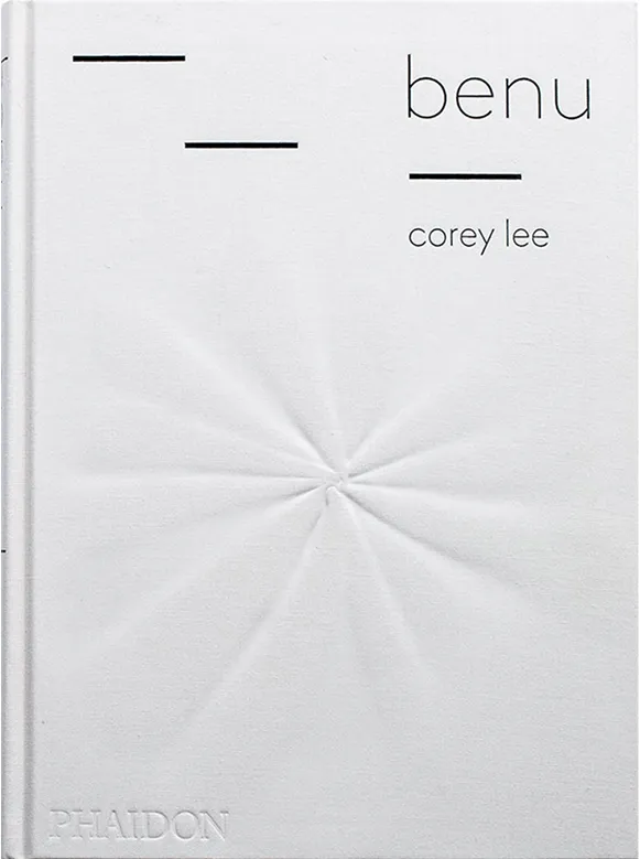 White hardcover book titled 'benu' by corey lee with black minimalist lines and embossed publisher name Phaidon.