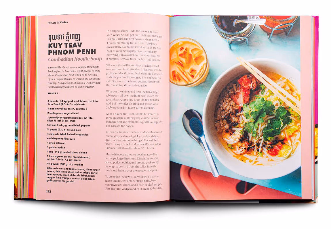 Open cookbook showing a Cambodian noodle soup recipe on the left page and a bowl of noodle soup with chopsticks, a spoon, and drinks on the right page.
