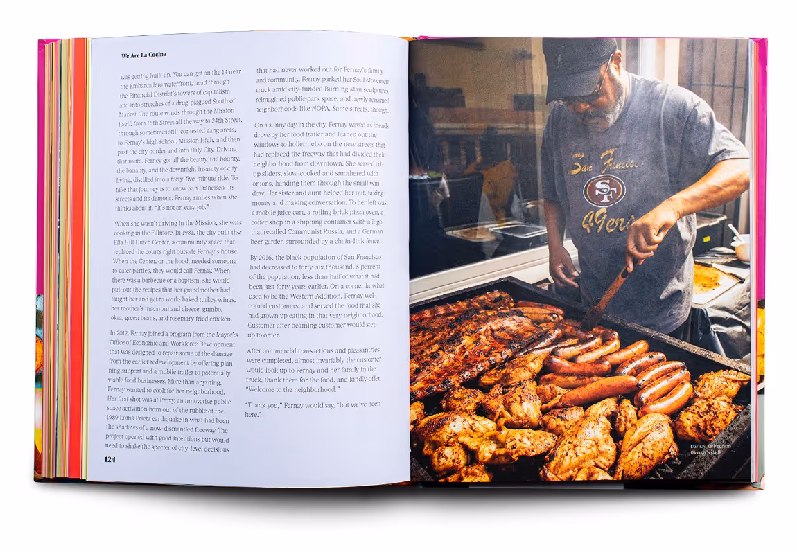 Open cookbook showing a page of text about La Cocina and a photo of a man grilling chicken and sausages.