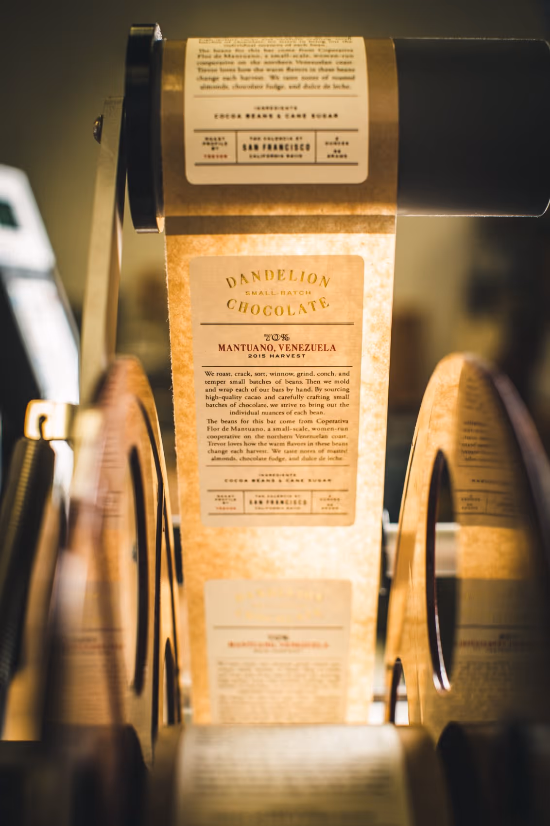 Roll of printed labels for Dandelion Chocolate 70% Mantuano, Venezuela, mounted on a machine.
